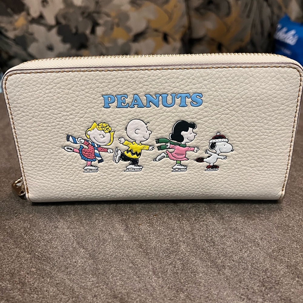 Coach X Peanuts Corner Zip Wristlet
With Snoopy And Friends Motif